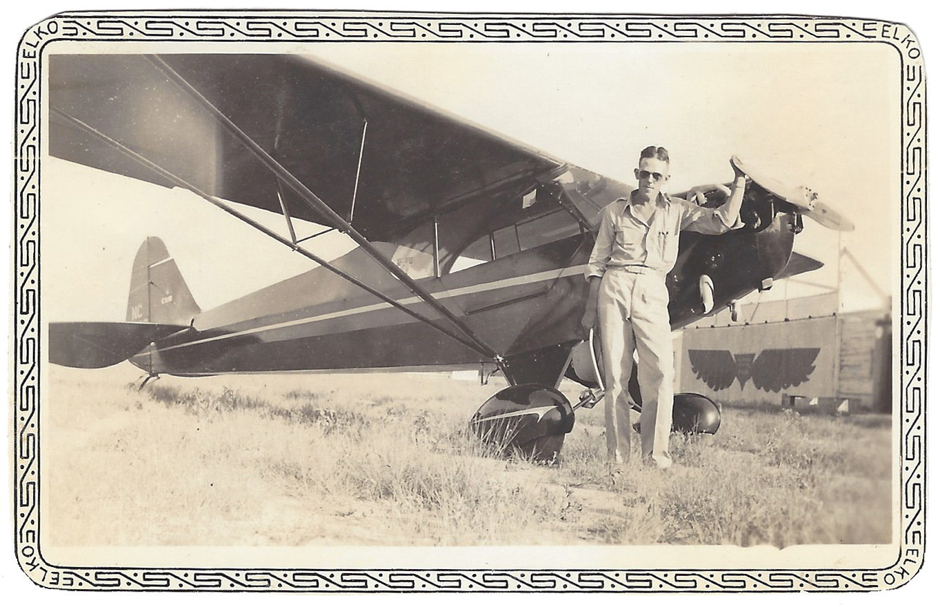 1939 Photo of Coulter Airfield showing Andrew G. Andersson with a single-engine plane and a hangar in the background.