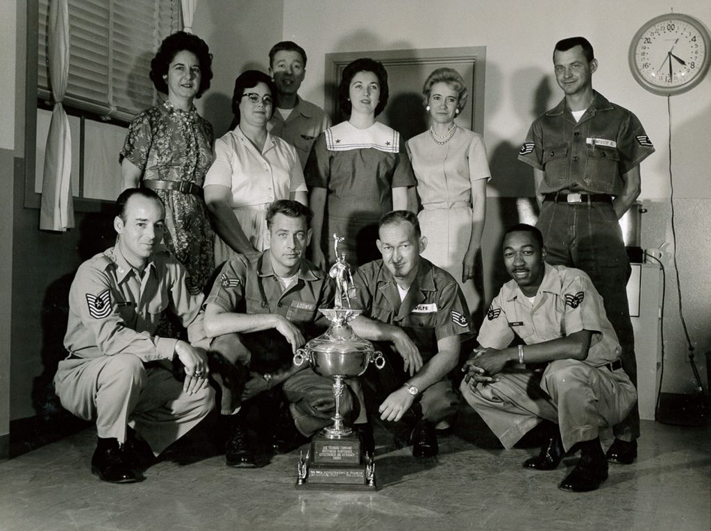 Bryan Air Force Base personnel and support staff members pose with the Air Training Command Outstanding Maintenance Effectiveness and Efficiency Trophy in the 1950s.